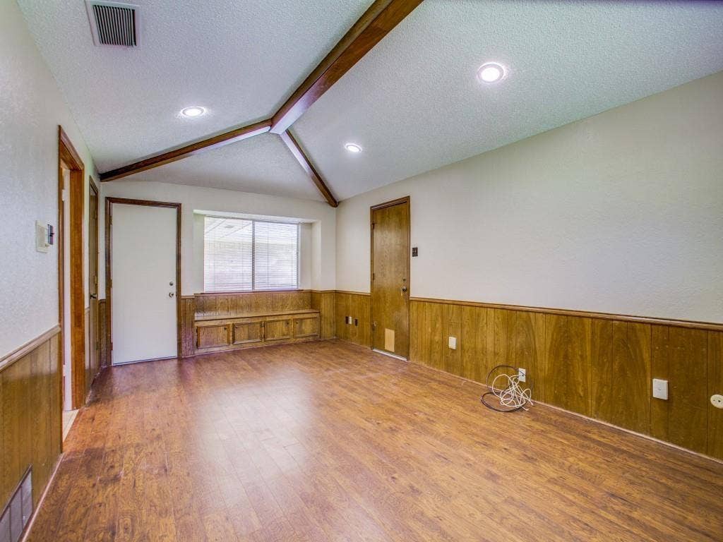 1103 Sundial Drive, Richardson, TX 75081 Vaulted ceiling with exposed wood beams, recessed lighting, wood-finish flooring, built-in window bench with storage, and wood paneling