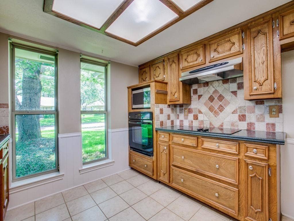 1103 Sundial Drive, Richardson, TX 75081 Oak cabinetry with paneling, built-in microwave, and double oven