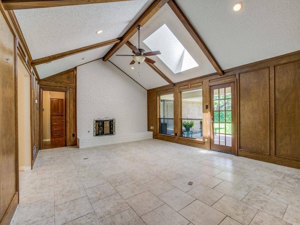 1103 Sundial Drive, Richardson, TX 75081 Vaulted ceiling with exposed wood beams, skylight, recessed lighting, white brick fireplace, and tile flooring