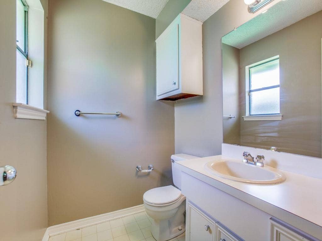 1103 Sundial Drive, Richardson, TX 75081 White vanity with integrated sink, chrome faucet, and mirrored wall