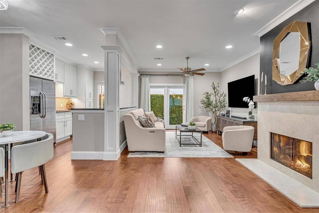 4242 Travis Street, #102, Dallas, TX 75205 Wood-finish flooring throughout, with a built-in fireplace, recessed lighting, and a ceiling fan