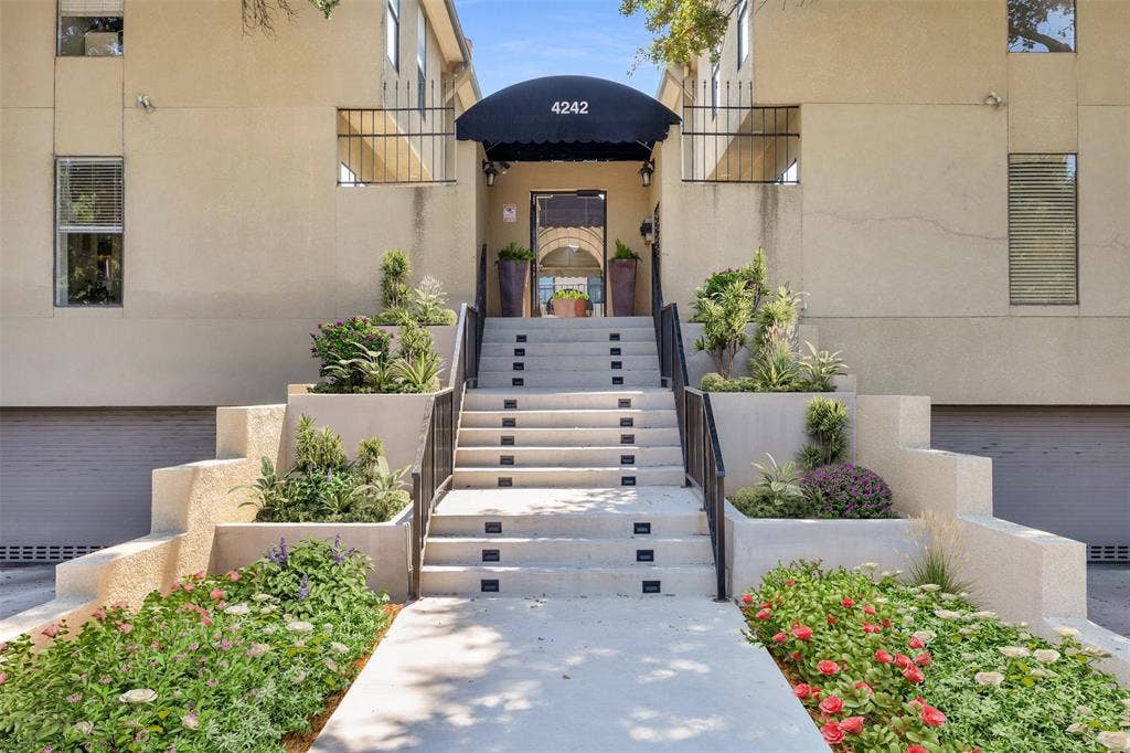 4242 Travis Street, #102, Dallas, TX 75205 Building front exterior with a covered entry, concrete steps, wrought iron handrails, integrated planters, and surrounding landscaping