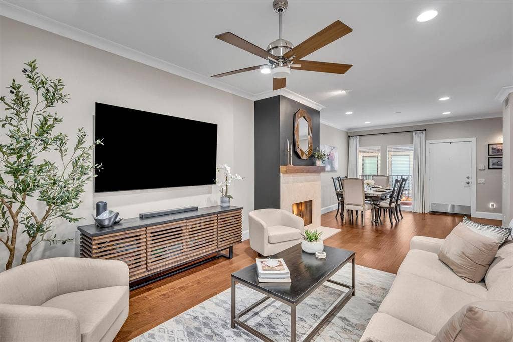 4242 Travis Street, #102, Dallas, TX 75205 Hardwood-finish flooring, recessed lighting, crown molding, and a built-in fireplace with a stone surround