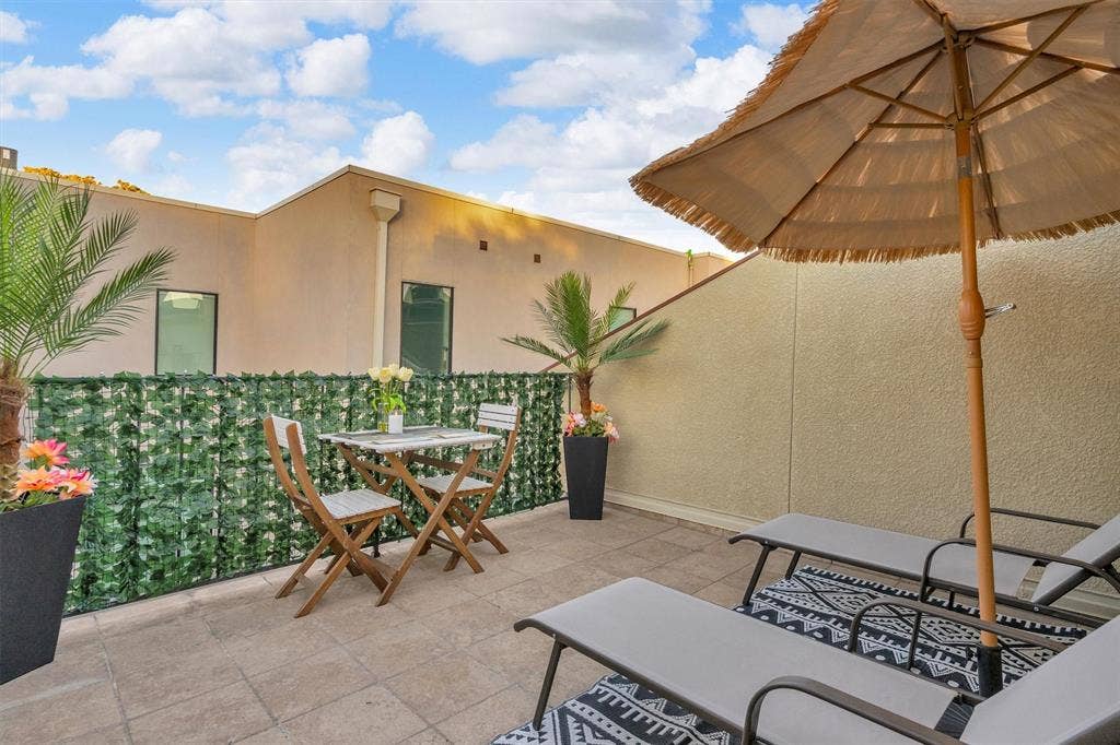 4242 Travis Street, #102, Dallas, TX 75205 Outdoor patio space with tile flooring, privacy screening, and stucco exterior walls