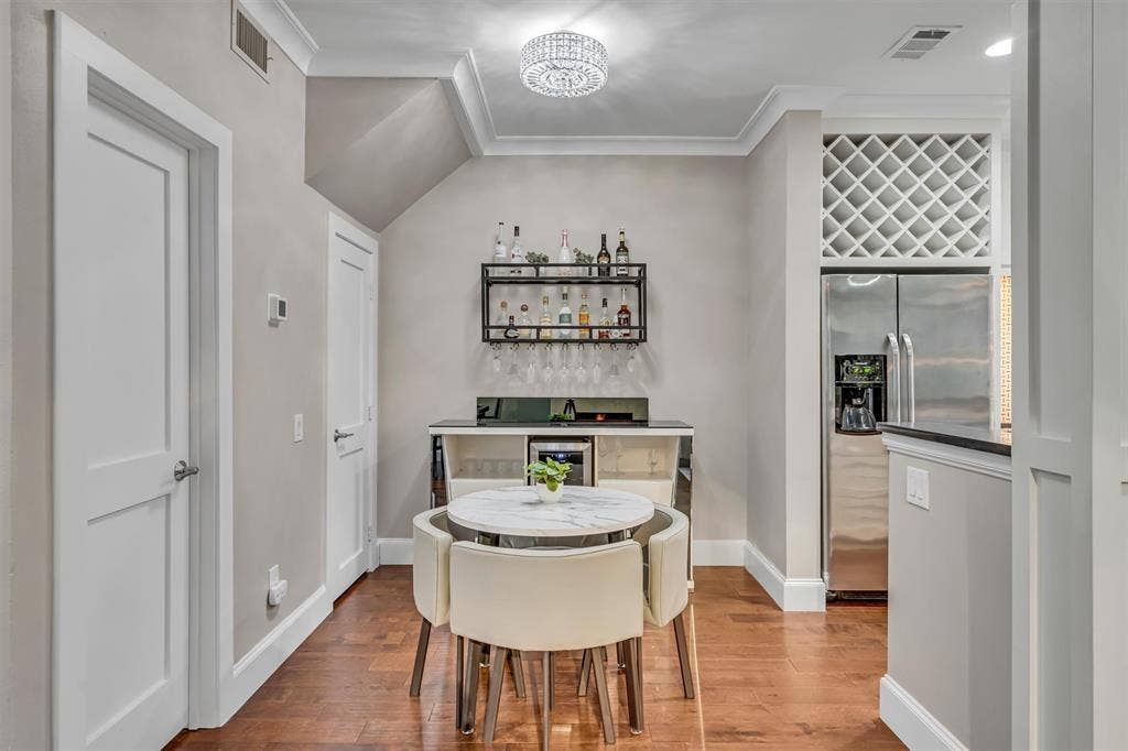 4242 Travis Street, #102, Dallas, TX 75205 Hardwood-style flooring, crown molding, built-in wine rack, and stainless steel refrigerator