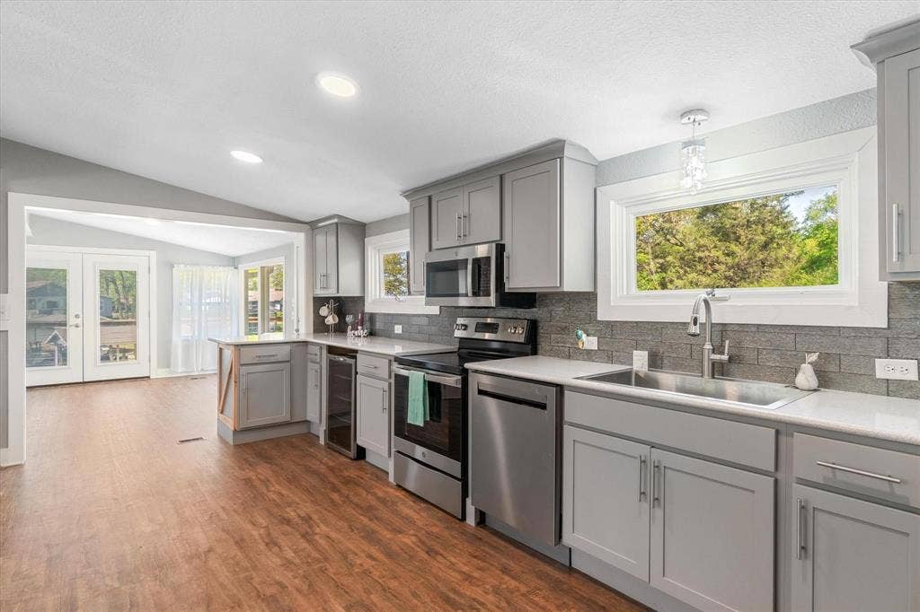 230 Shady Shores Drive, Mabank, TX 75156 Kitchen featuring light gray cabinetry, stainless steel appliances, light-toned countertops, and a gray tile backsplash
