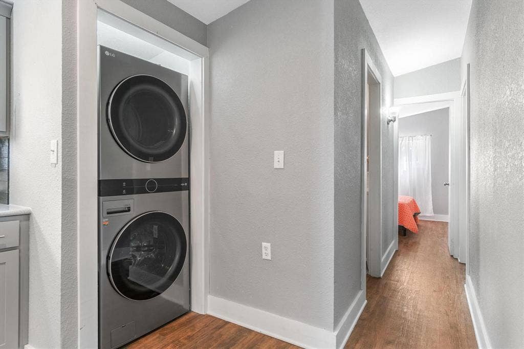 230 Shady Shores Drive, Mabank, TX 75156 Stackable laundry machines, wood-finish flooring, and wall-mounted light fixture