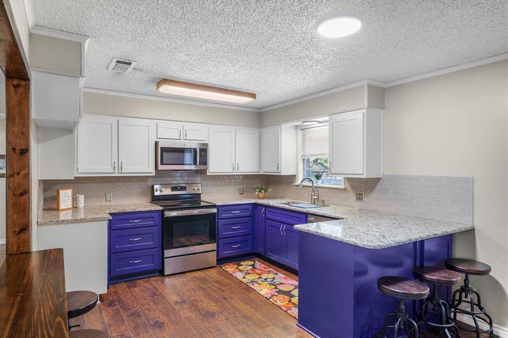 2941 Trey Circle, Athens, TX 75752 Granite countertops, breakfast bar and violet painted cabinets make this an uplifting kitchen