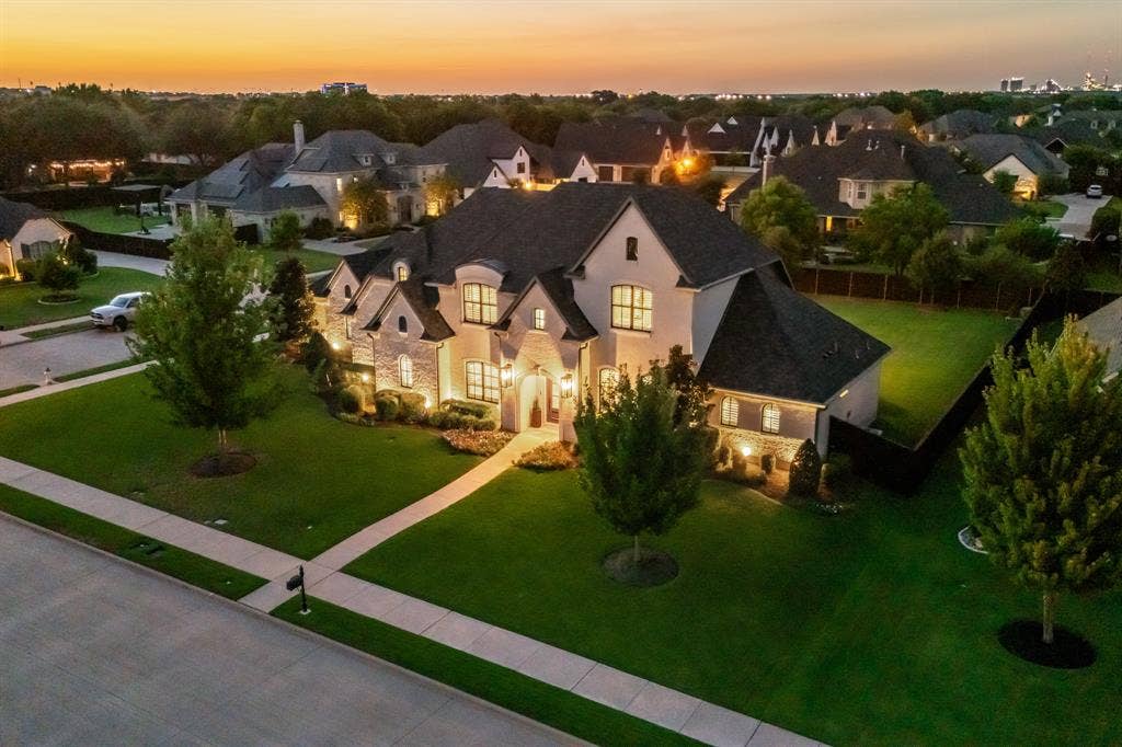 2201 Hanna Court, Midlothian, TX 76065 Twilight aerial view captures the custom stone-and-brick facade on nearly half an acre in gated Somercrest Estates.