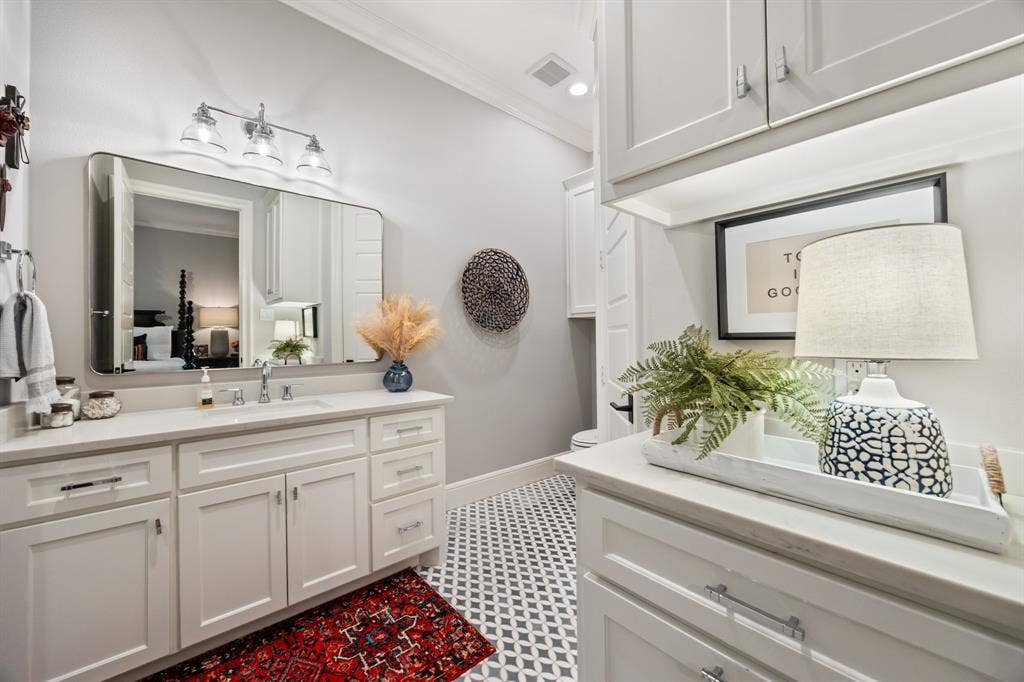 2201 Hanna Court, Midlothian, TX 76065 Crisp white cabinetry and a large mirror keep this en-suite bath bright and airy.