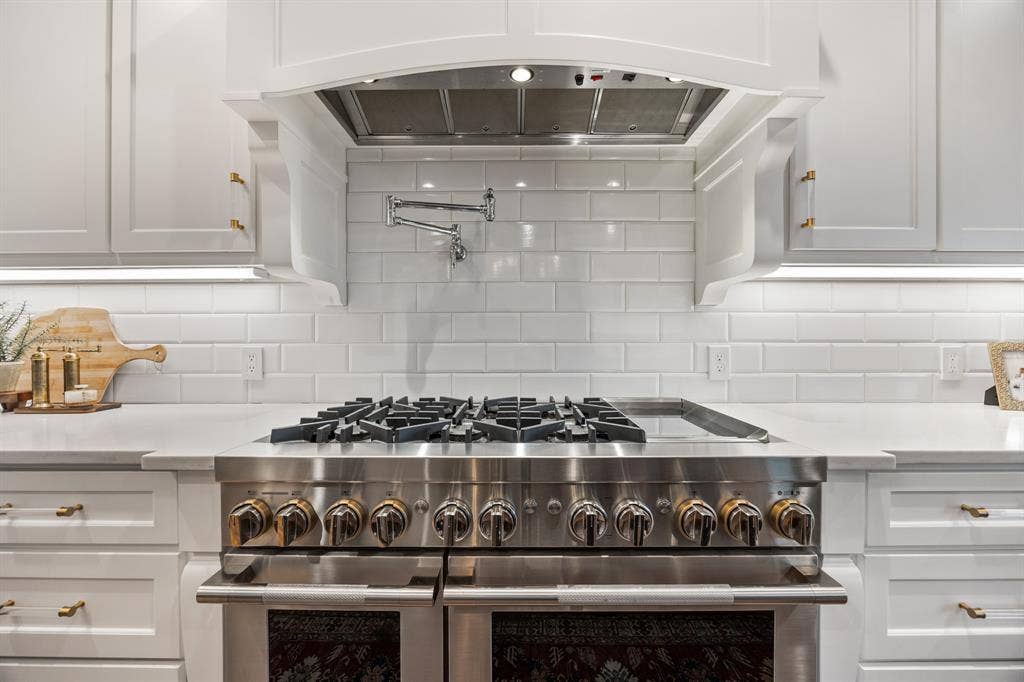 2201 Hanna Court, Midlothian, TX 76065 JennAir range and hood take center stage against a striking marble backsplash.