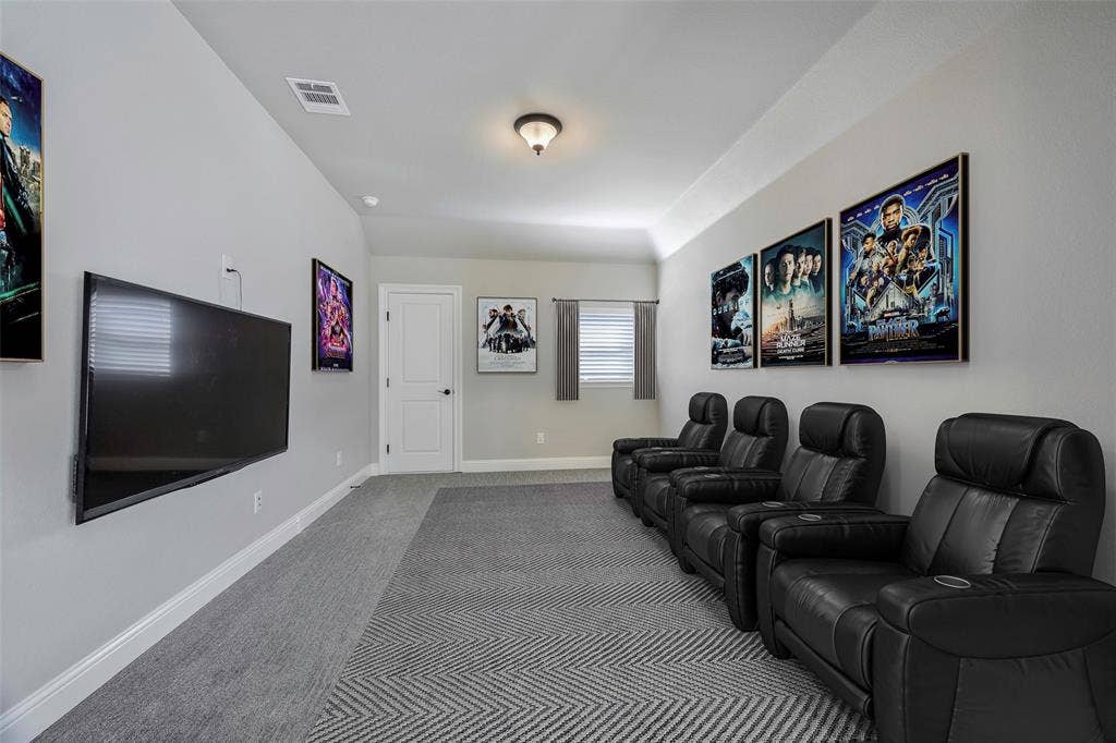 941 Leola Lane, Allen, TX 75013 Vaulted ceiling with an attached light fixture, wall-mounted television, and a white interior door with black hardware