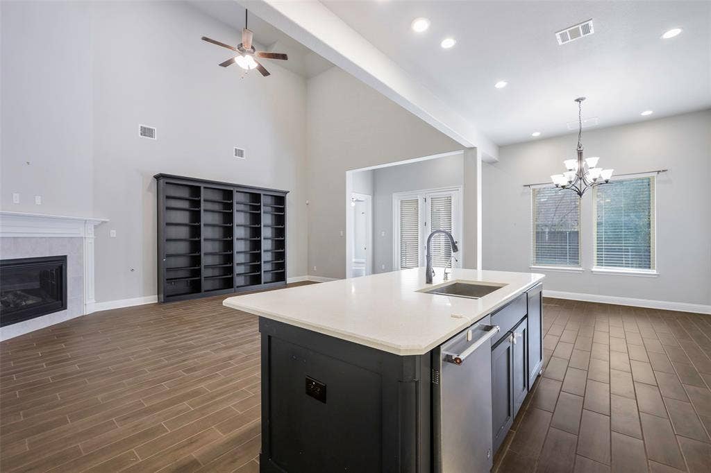 941 Leola Lane, Allen, TX 75013 Vaulted ceilings, wood-finish flooring, built-in shelving, fireplace with mantel, kitchen island with sink and stainless steel dishwasher