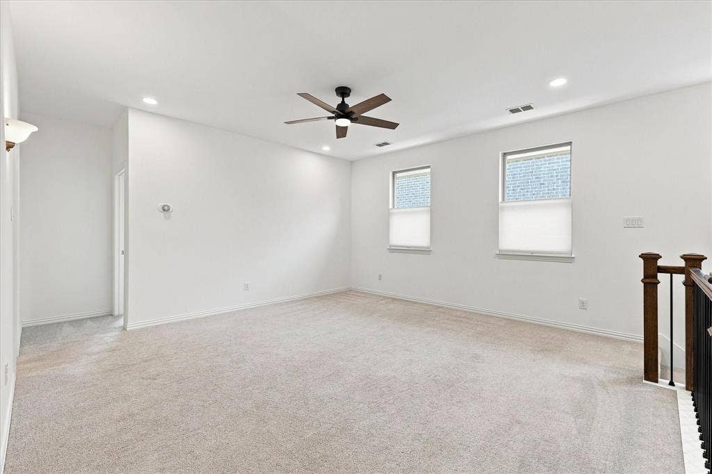3109 Taunton Way, McKinney, TX 75069 Carpeted room with recessed lighting, a ceiling fan, two windows, and a wood and metal railing