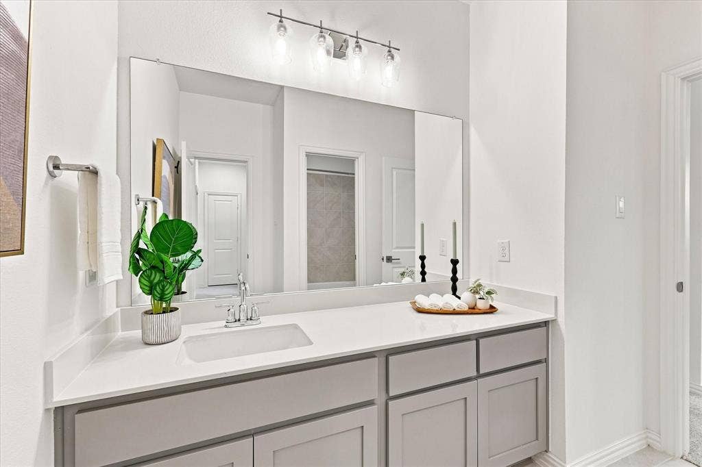 3109 Taunton Way, McKinney, TX 75069 Vanity with light gray shaker cabinetry, a white countertop, an undermount sink, and a large mirror