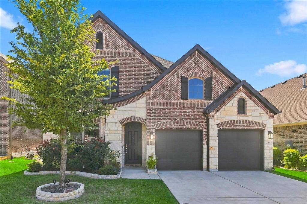 3109 Taunton Way, McKinney, TX 75069 Brick and stone exterior featuring arched entryways, a two-car garage, and a concrete driveway