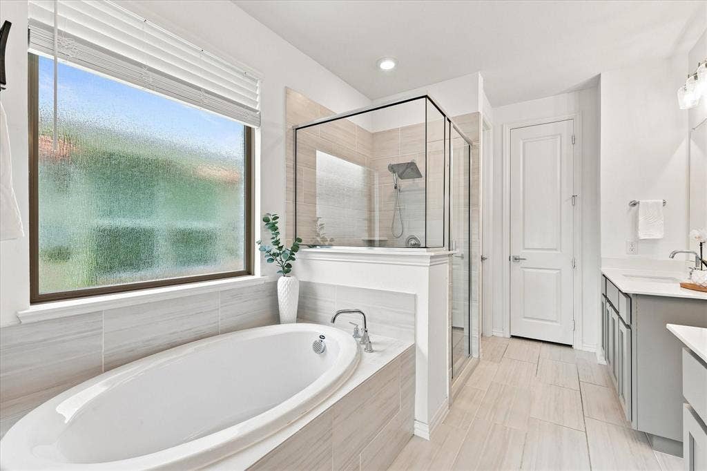 3109 Taunton Way, McKinney, TX 75069 Soaking tub with surrounding tiled deck, glass-enclosed shower, dual vanity with undermount sinks, and tiled flooring