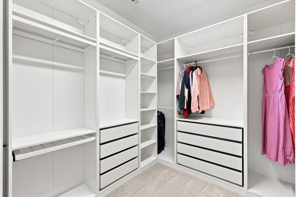 3109 Taunton Way, McKinney, TX 75069 Custom closet system featuring multiple hanging rods, integrated shelving, and built-in drawers with black hardware