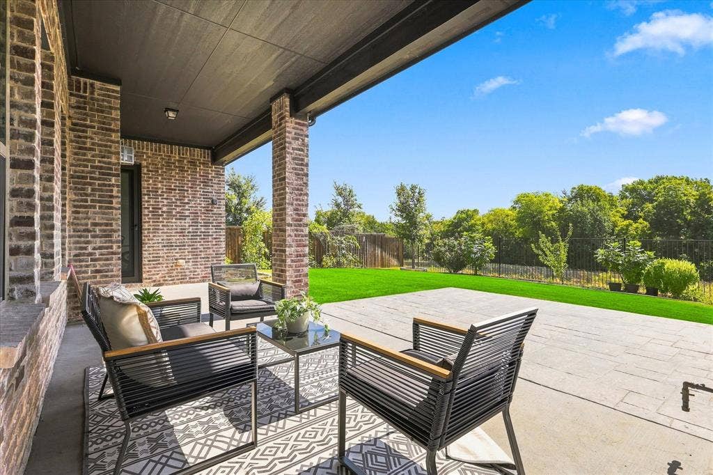 3109 Taunton Way, McKinney, TX 75069 Covered patio with brick columns, recessed lighting, concrete flooring, and a manicured lawn beyond