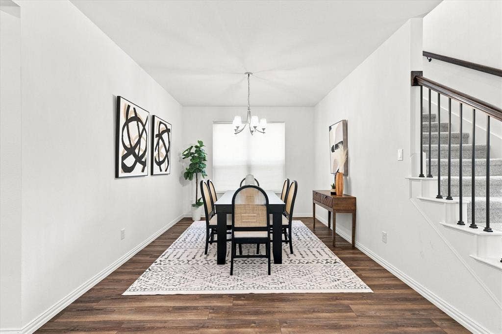 3109 Taunton Way, McKinney, TX 75069 Wood-finish flooring, staircase with carpeted treads and wrought iron balusters, white wall finishes, and a chandelier lighting fixture