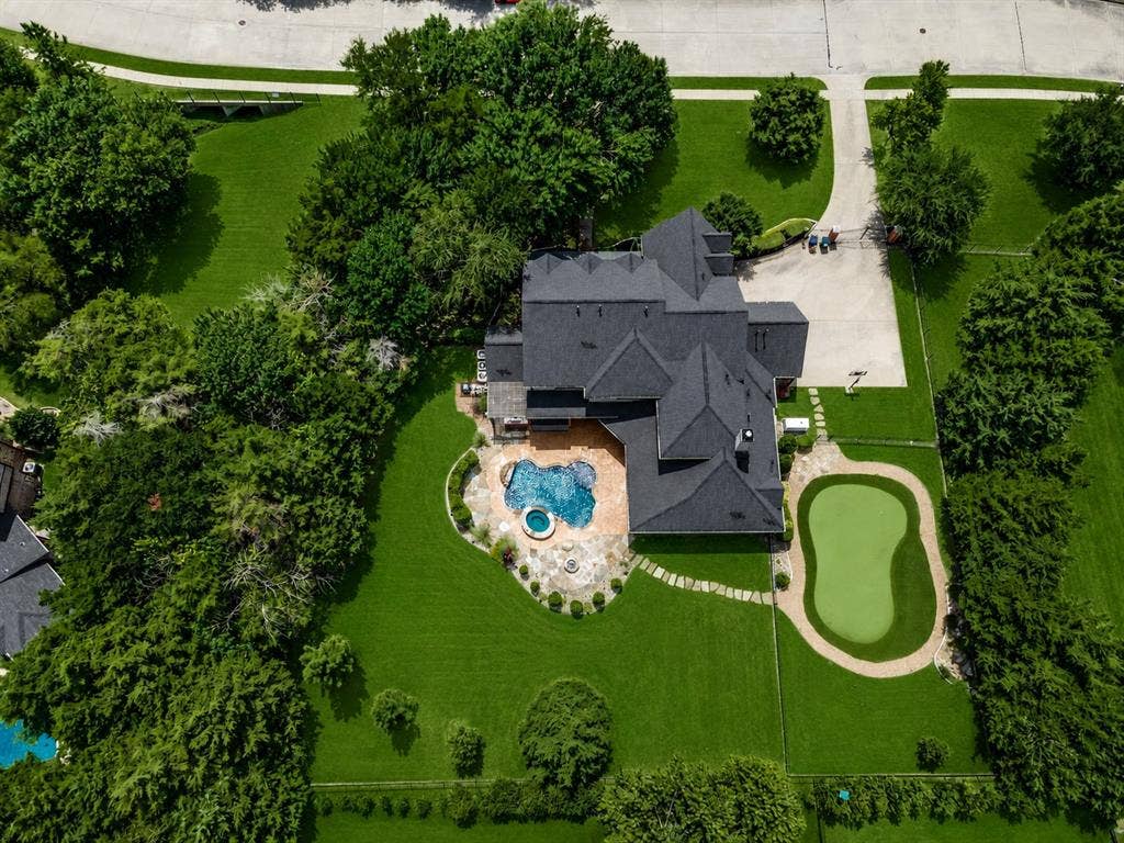 424 Wyndemere Boulevard, Heath, TX 75032 Expansive property featuring a multi-level roofline, large swimming pool with integrated spa, putting green, and a generously sized driveway