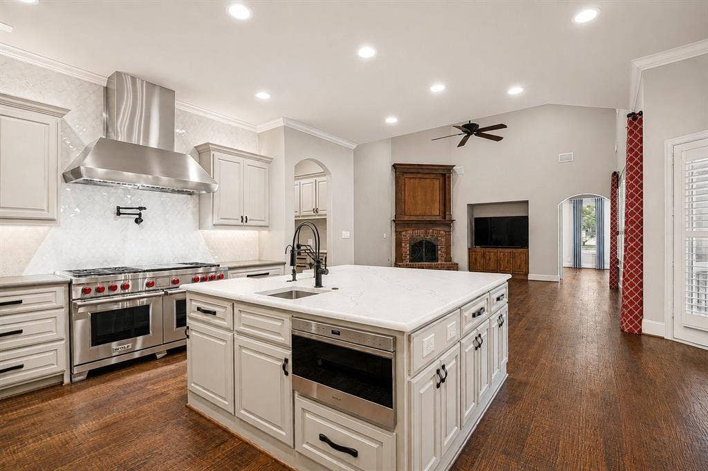 424 Wyndemere Boulevard, Heath, TX 75032 Gourmet kitchen with professional-grade stainless steel appliances, solid surface countertops, light-toned cabinetry, and wood-finish flooring