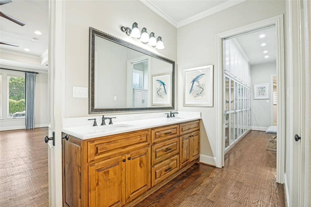 424 Wyndemere Boulevard, Heath, TX 75032 Dual undermount sinks set in a white countertop with wood-finish cabinetry