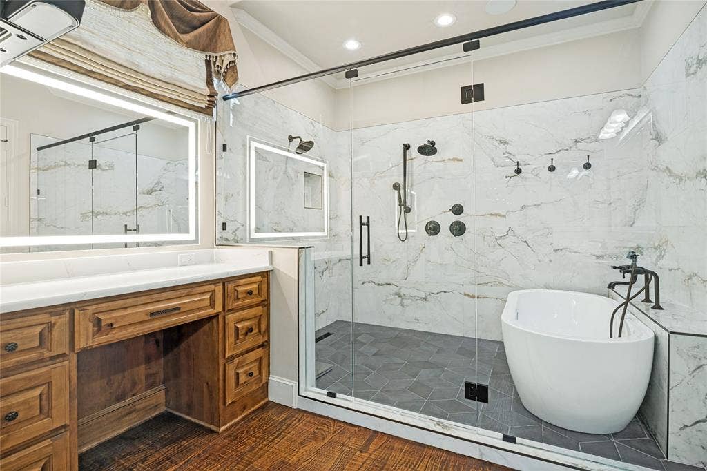 424 Wyndemere Boulevard, Heath, TX 75032 Hardwood-finish flooring leading to a freestanding tub and a spacious glass-enclosed shower with wall-mounted showerheads