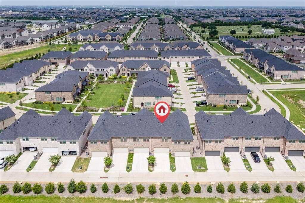 Townhome architecture with brick and siding facades, private driveways, and individual garage access