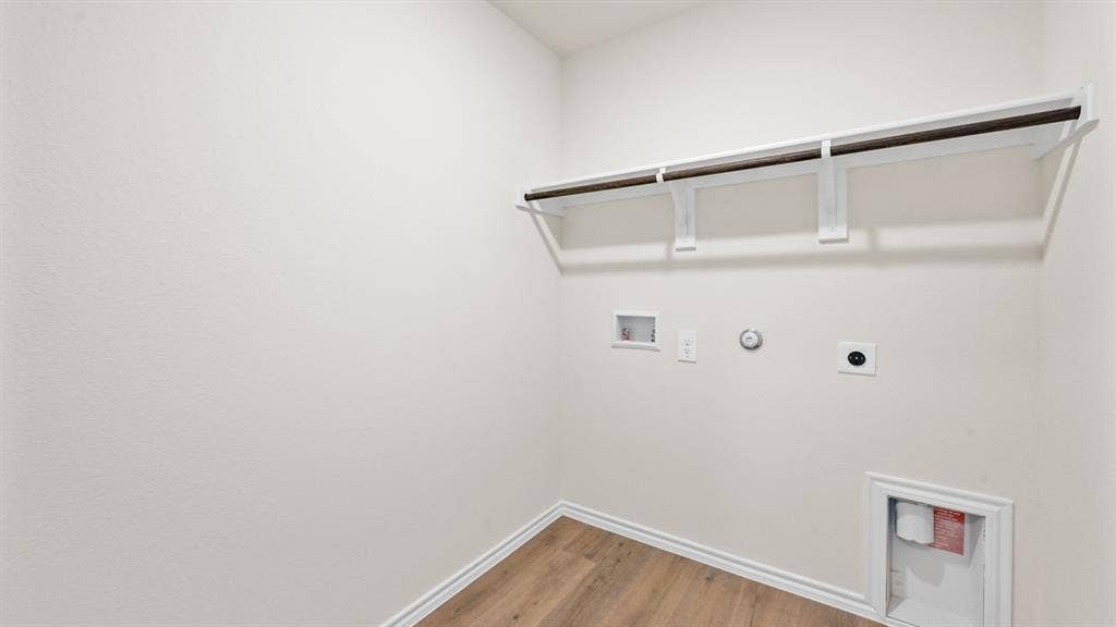 Wood-finish flooring, overhead shelving, and a hanging rod
