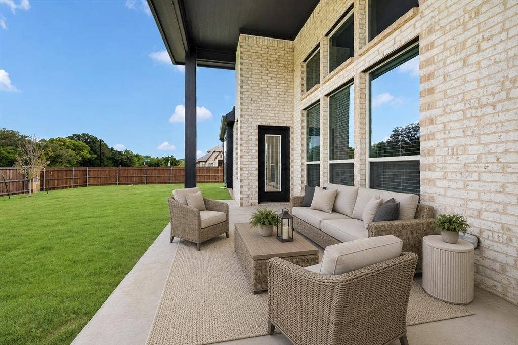 2600 Gavin Drive, Mansfield, TX 76063 Covered patio with a light brick exterior, large windows, and a black exterior door