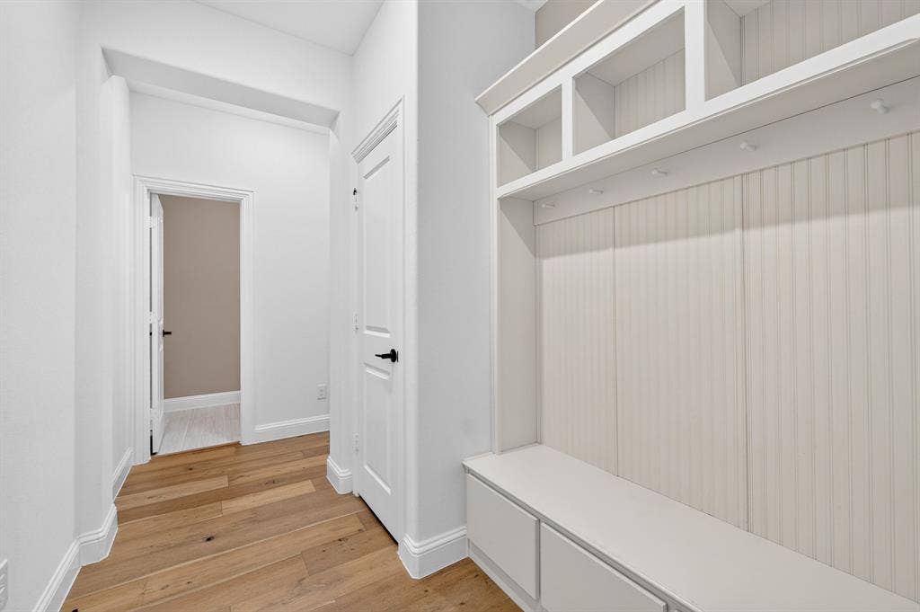 2600 Gavin Drive, Mansfield, TX 76063 Bright mudroom featuring warm wood-finish flooring, white shiplap wainscoting, and custom built-in cabinetry with open shelving