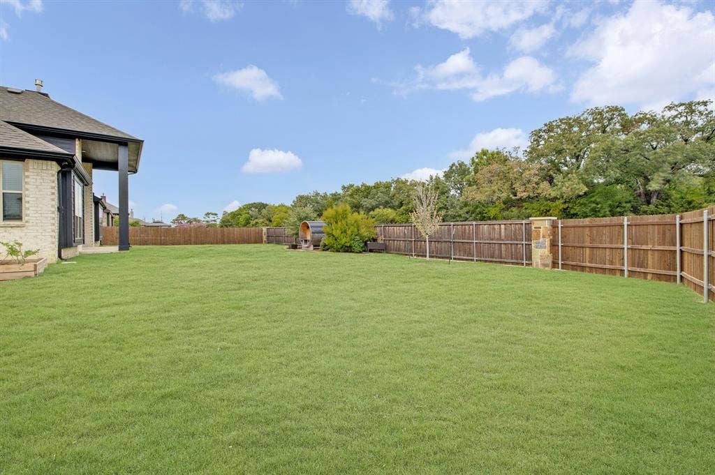 2600 Gavin Drive, Mansfield, TX 76063 Expansive backyard featuring a meticulously manicured lawn, mature landscaping with established trees, and sturdy wood-finish fencing