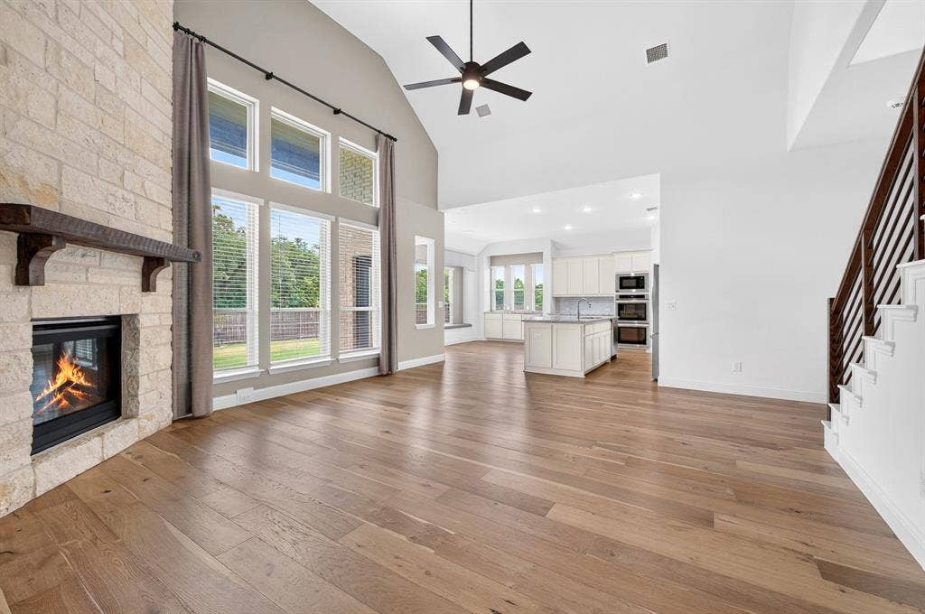 2600 Gavin Drive, Mansfield, TX 76063 Open-concept living space featuring soaring ceilings, a ceiling fan, and abundant natural light from expansive multi-pane glass doors and windows