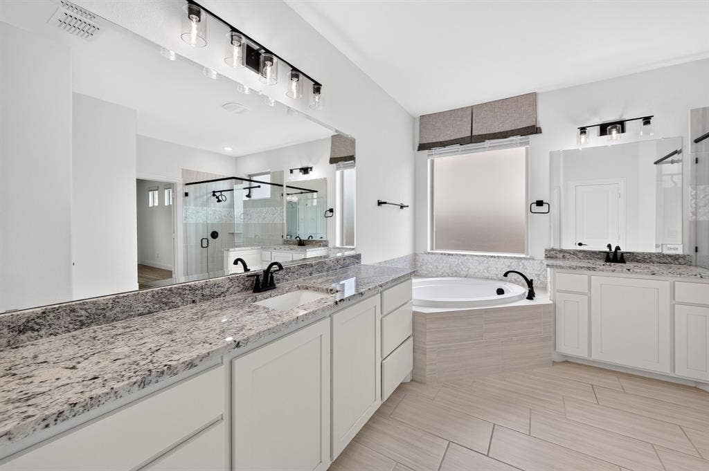 2600 Gavin Drive, Mansfield, TX 76063 Owner's bathroom with dual vanity, granite countertops, and matte black fixtures