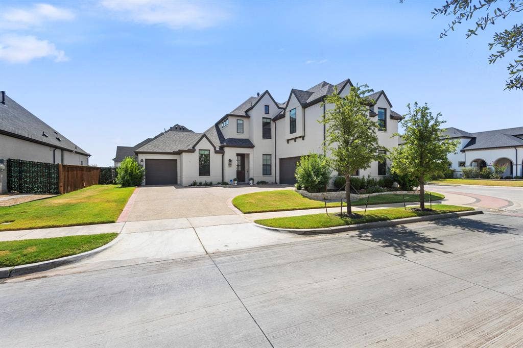 Contemporary white exterior with dark trim, multiple gables, and a two-car garage