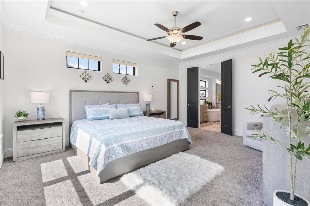 Recessed lighting, ceiling fan, tray ceiling, carpeted flooring, and double doors