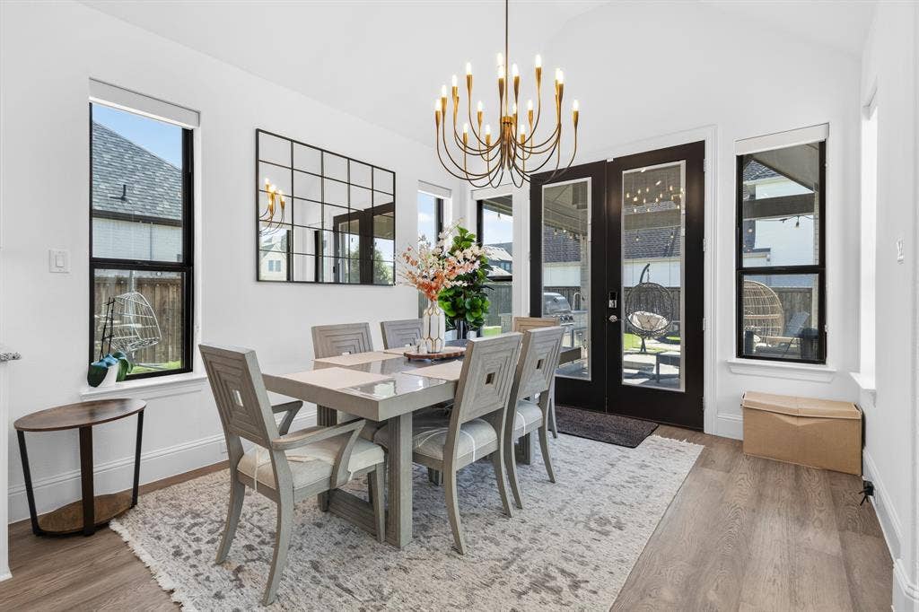 Vaulted ceiling accentuates the elegant chandelier, complemented by multiple windows providing natural light