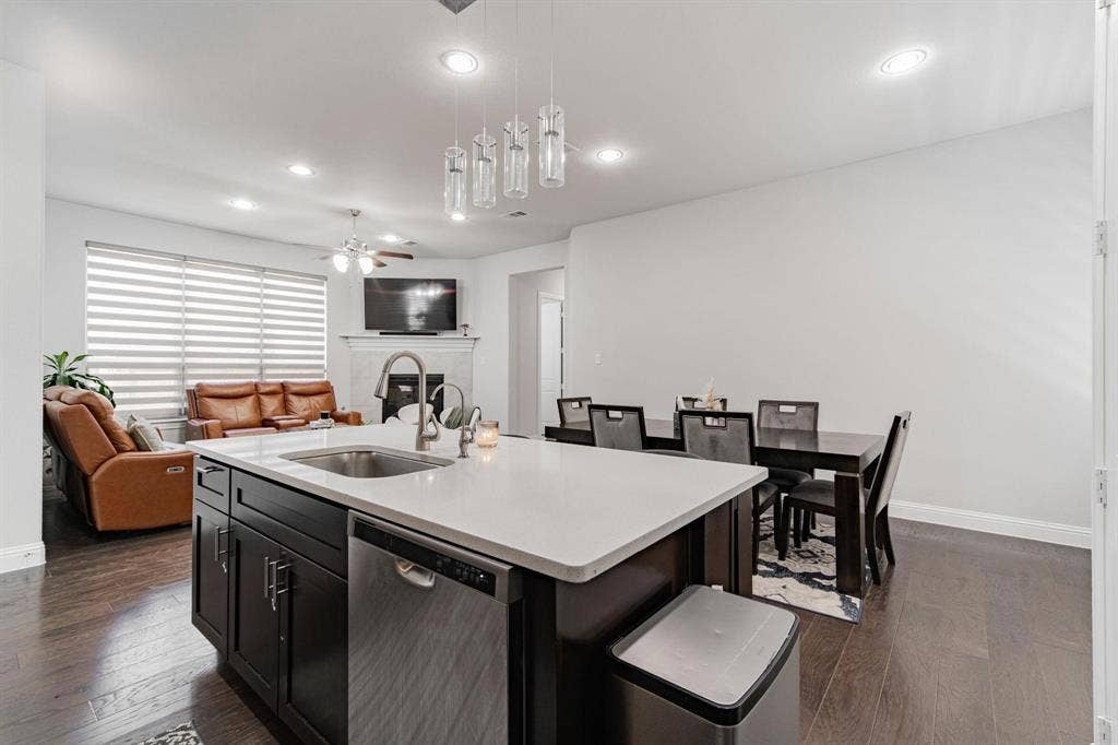 Kitchen island with an undermount sink, a dishwasher, and pendant lighting