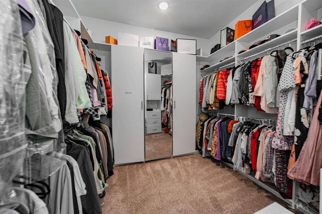 Custom closet system featuring built-in shelving, hanging rods, and an integrated full-length mirror
