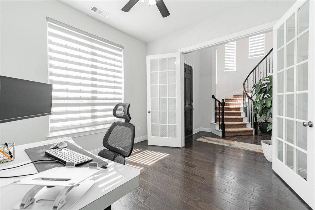 Hardwood-finish flooring, French doors with clear glass panels, a large window with horizontal blinds, and a ceiling fan