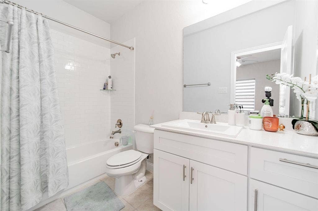 White subway tile shower surround with a built-in tub and a single vanity