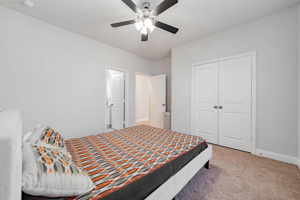 Neutral wall paint, ceiling fan with integrated lighting, paneled bifold closet doors, and carpet flooring
