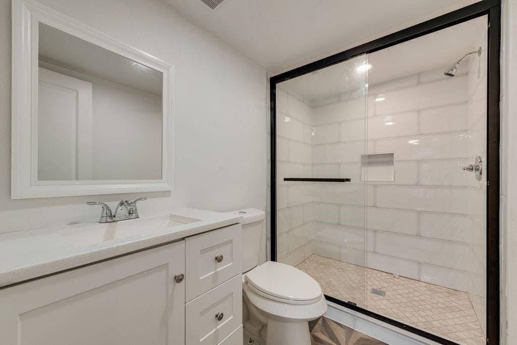 307 N 4th Street, Crandall, TX 75114 White shaker vanity with integrated sink, chrome faucet, and framed mirror