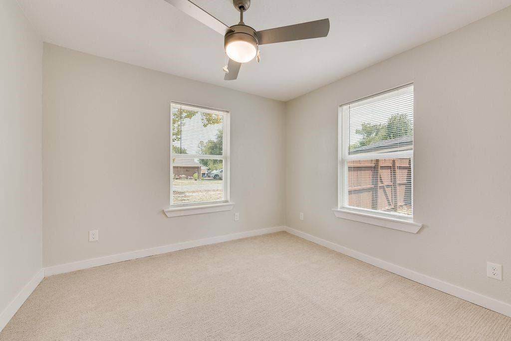 307 N 4th Street, Crandall, TX 75114 Neutral wall finishes, dual window placements, ceiling fan with integrated lighting, and carpeted flooring