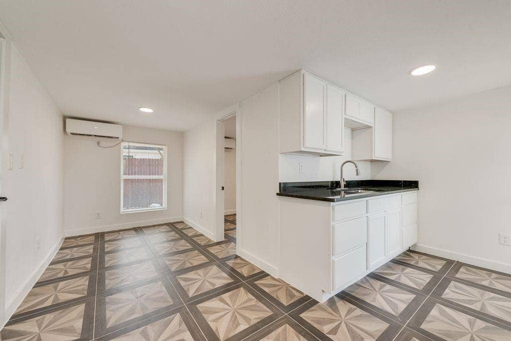 307 N 4th Street, Crandall, TX 75114 Guest Quarters Compact kitchen area with white cabinetry, dark countertops, and a stainless steel sink