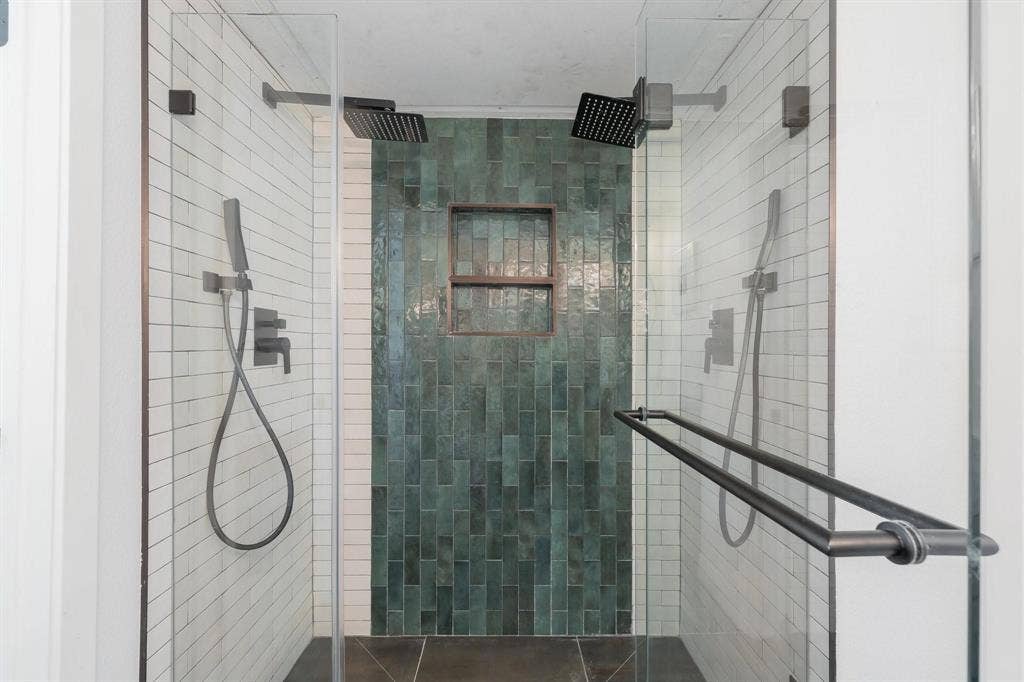 1805 W Spring Creek Parkway, #MM2, Plano, TX 75023 Glass-enclosed shower featuring dual rain shower heads, a handheld shower fixture, a recessed tiled niche, and dark-toned floor tiling