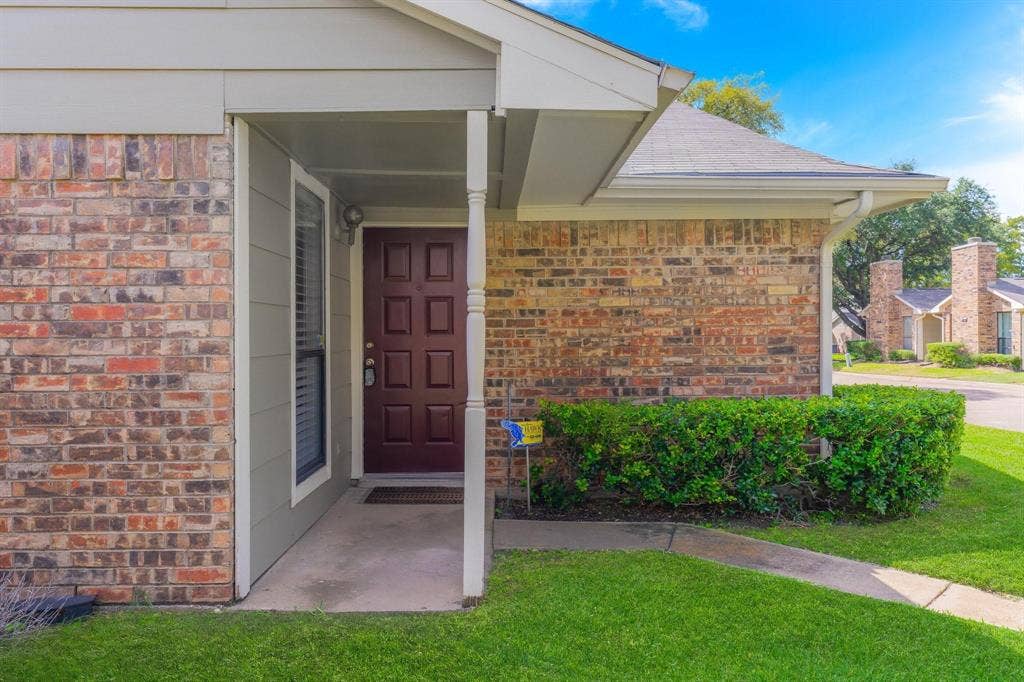1805 W Spring Creek Parkway, #MM2, Plano, TX 75023 Brick facade with light siding accents, covered entry porch, and a paneled entry door