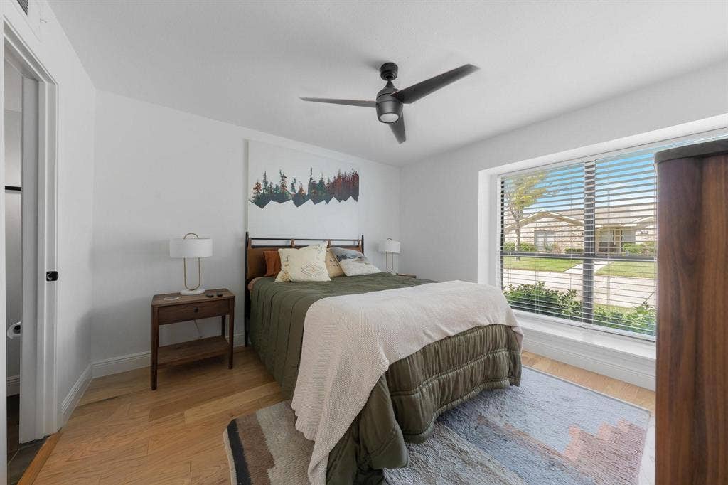 1805 W Spring Creek Parkway, #MM2, Plano, TX 75023 Expansive window with blinds, modern ceiling fan, light wood-finish flooring, and white walls