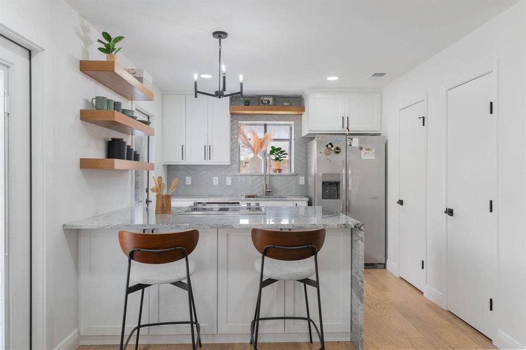 1805 W Spring Creek Parkway, #MM2, Plano, TX 75023 Kitchen featuring white cabinetry, light-toned wood-finish flooring, a central island with a light-colored countertop, and a stainless steel refrigerator